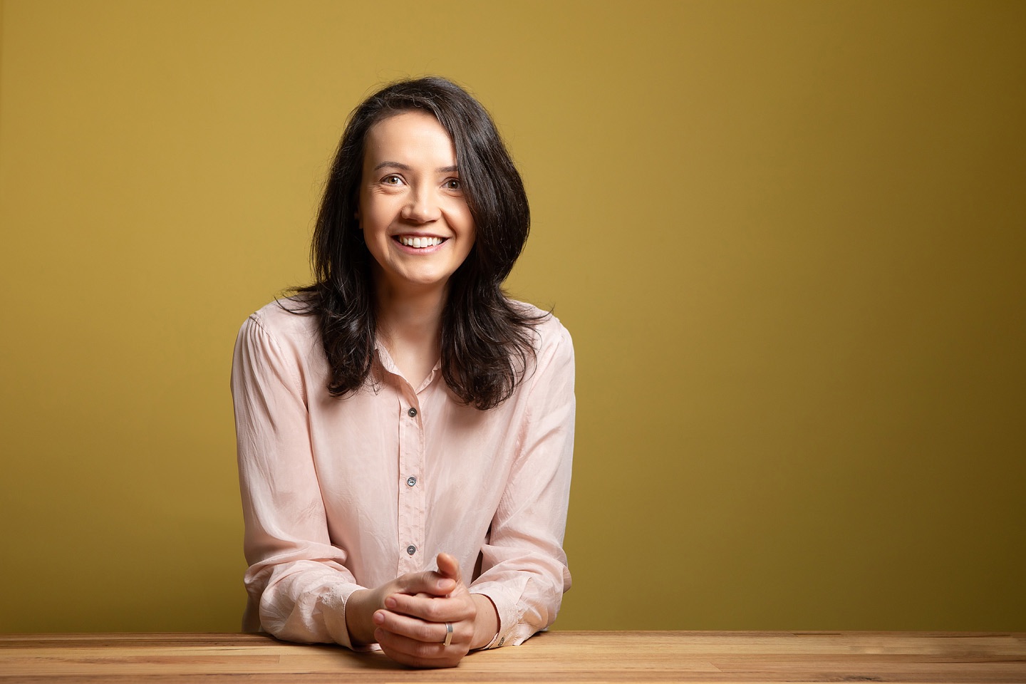 Studio headshot on a coloured backdrop