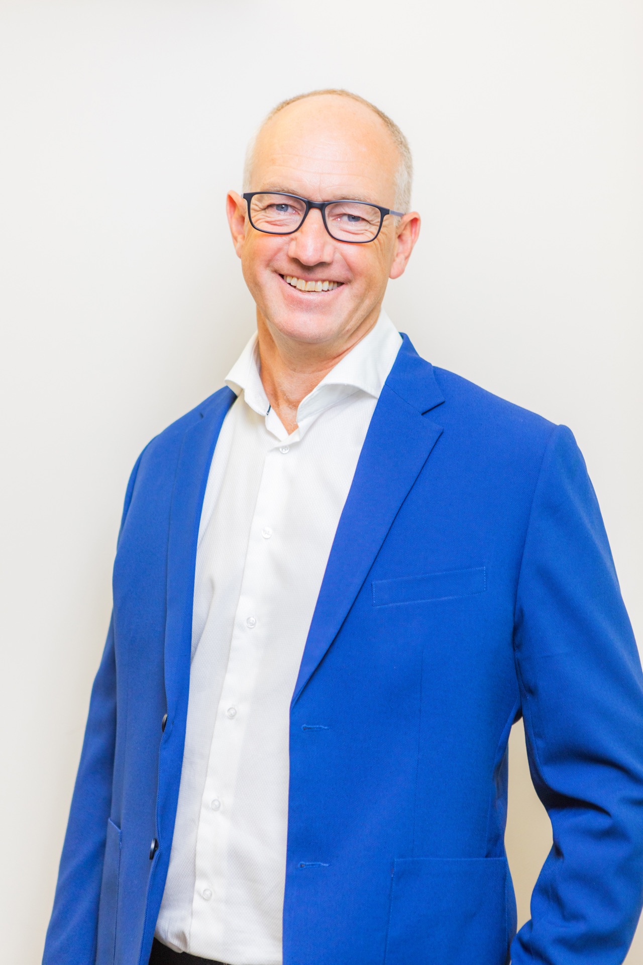 Corporate headshot against a plain wall