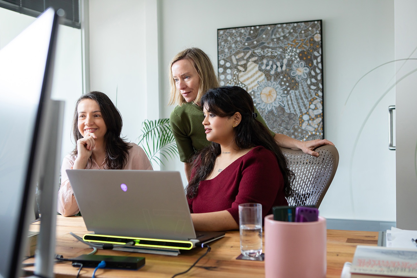 Colleagues sharing a laugh at a laptop