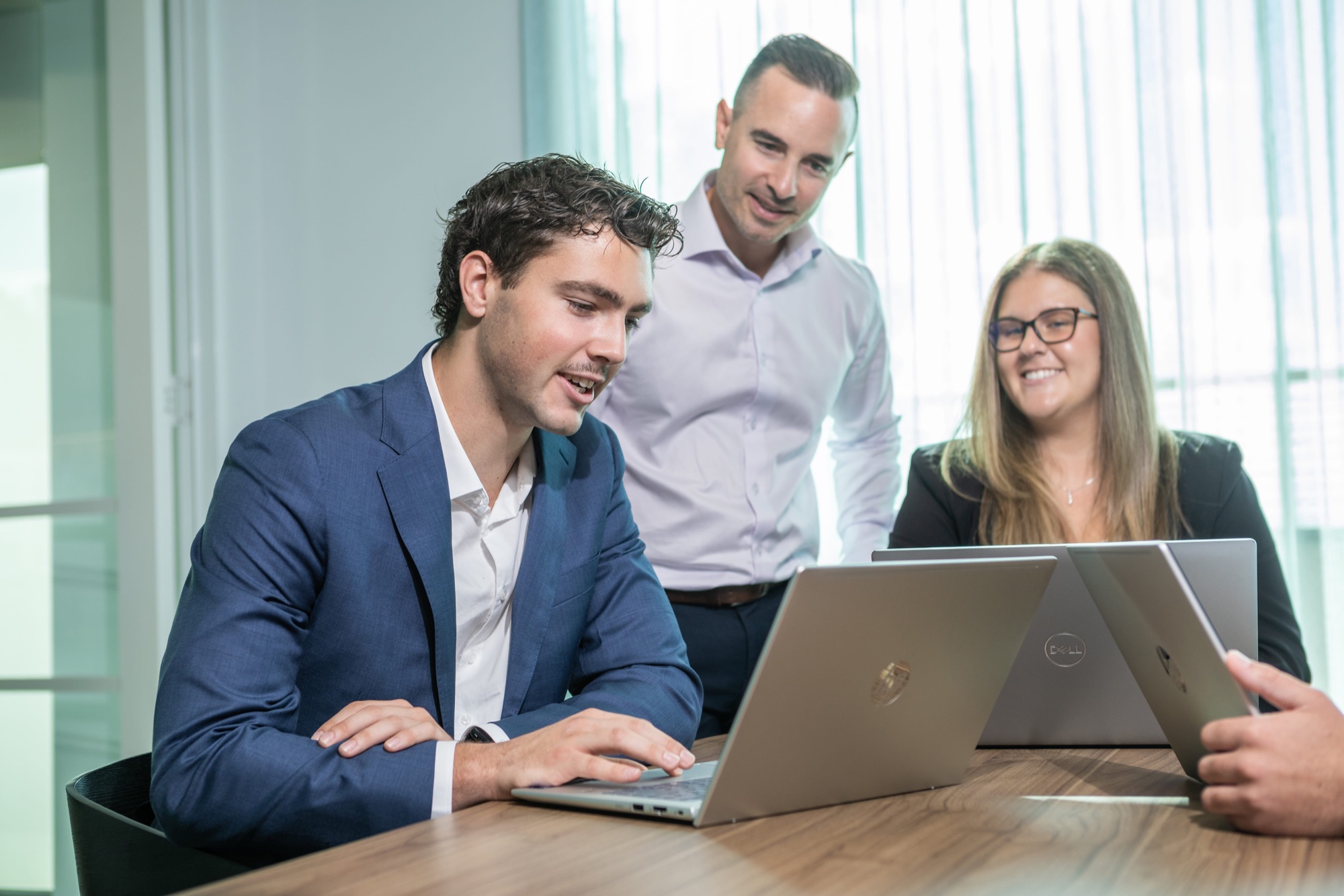 Colleagues working around a laptop